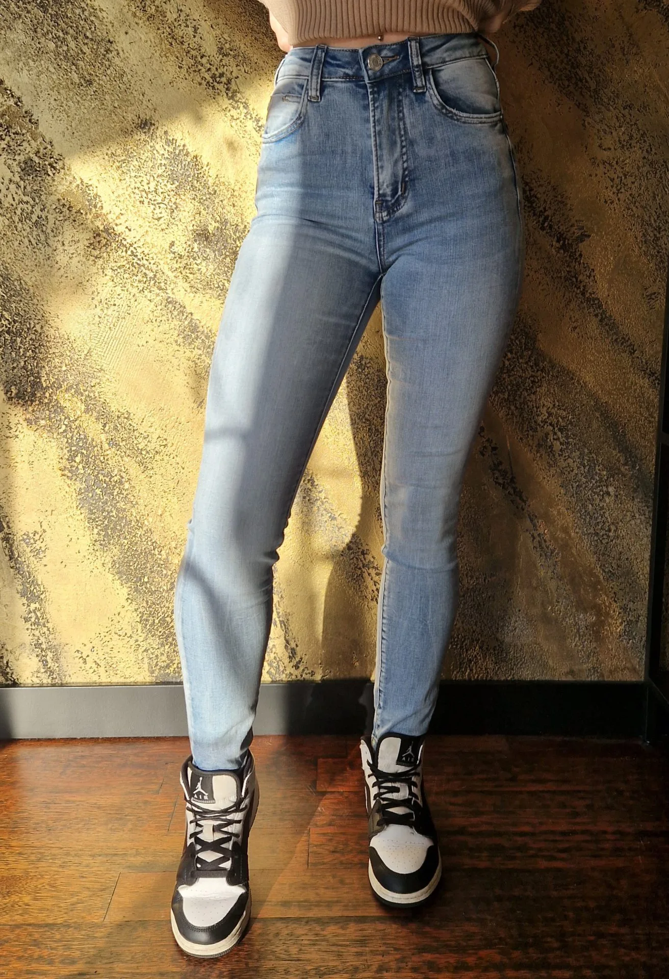 A fit girl wearing skintight jeans, frontal view of the crotch.
