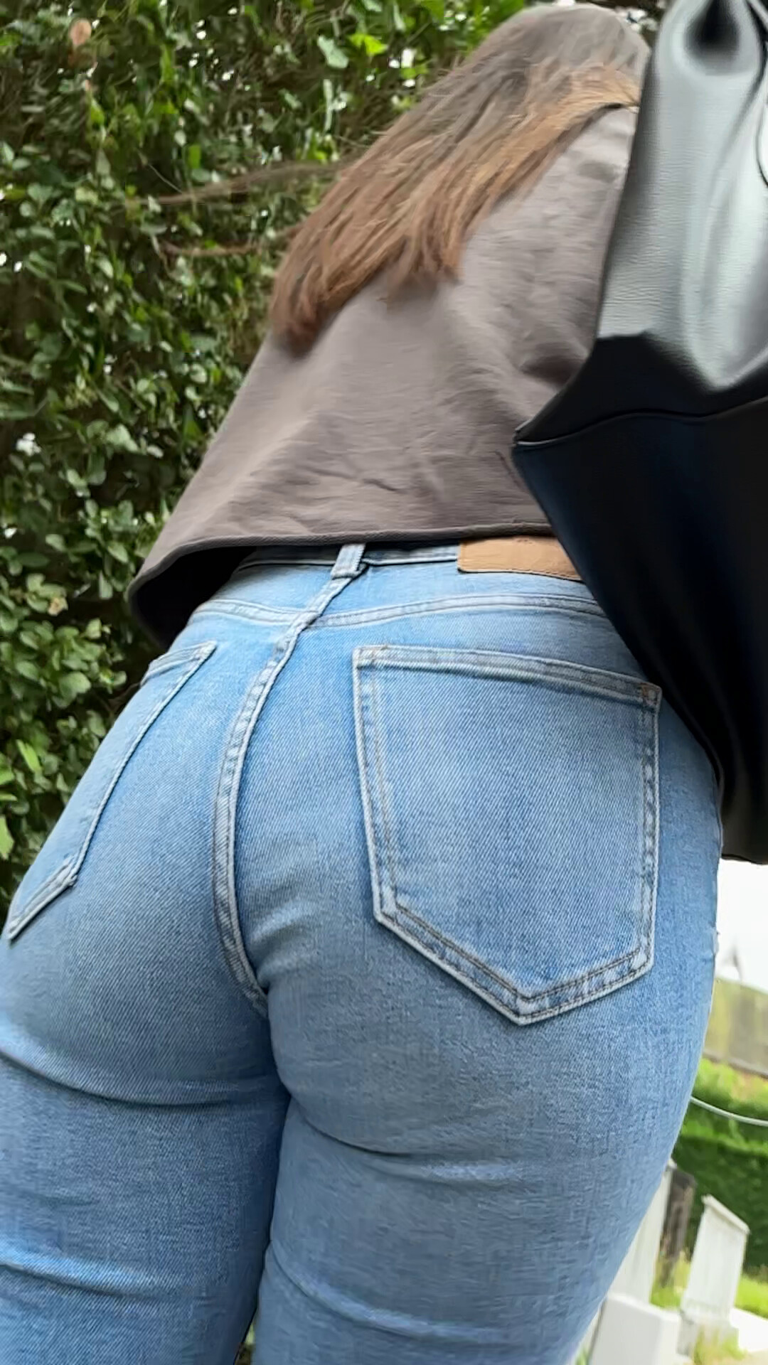 A bottom up view of a sexy ass of a candid girl in tight jeans.