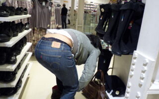 Photo of a girl bending over in tight Levis jeans in a store.